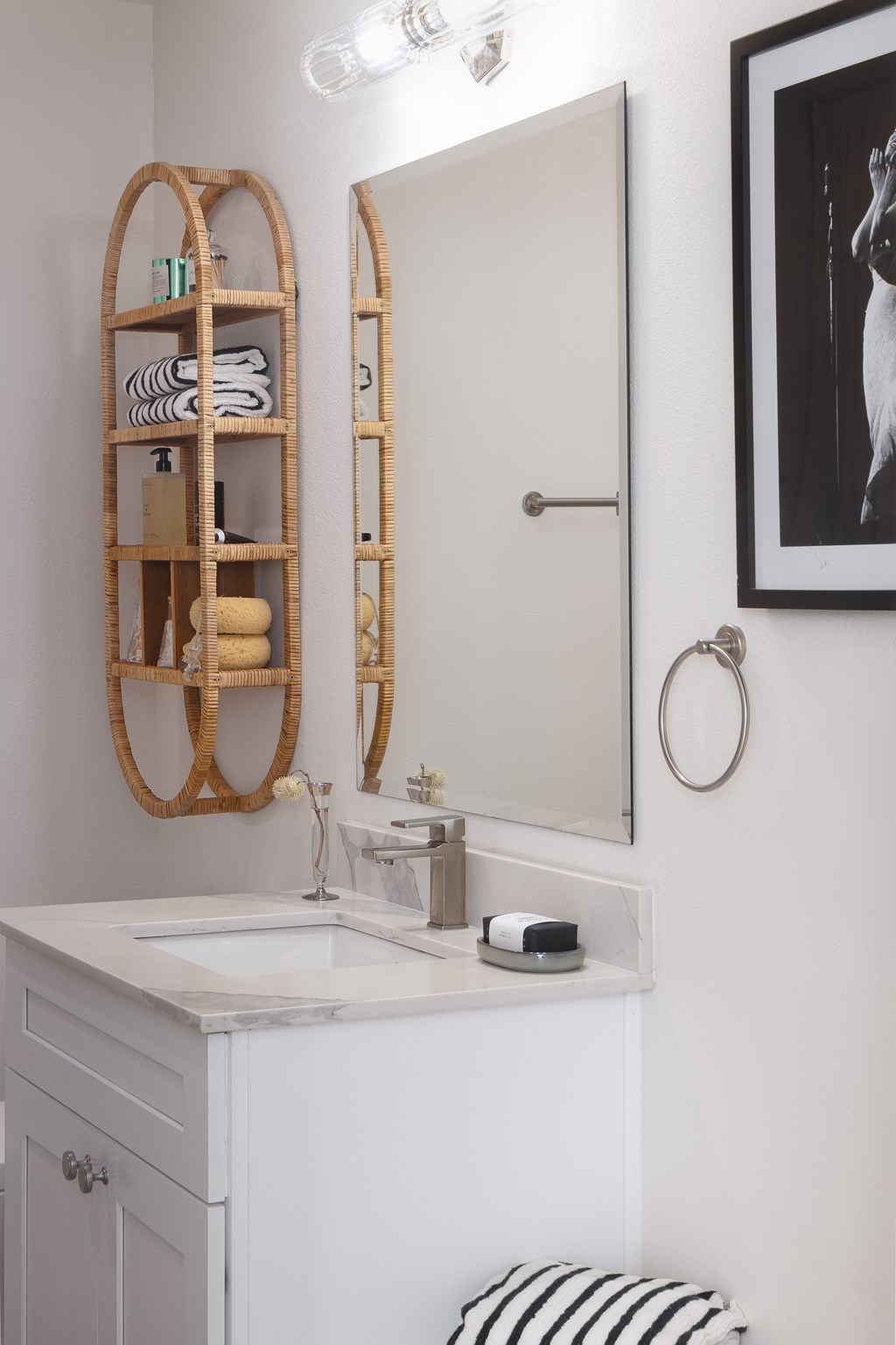 A bathroom with a white vanity and a round mirror at The PARKER on E Mulberry Apartments, Texas