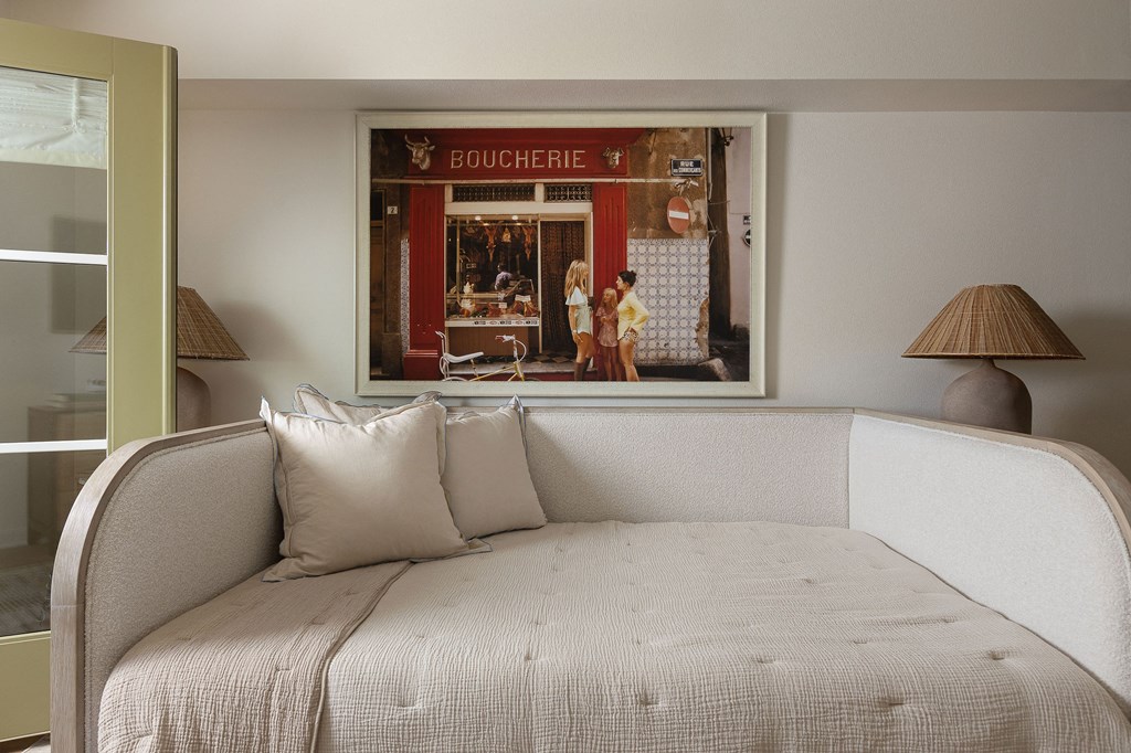 A bedroom with a bed and a picture of a bakery on the wall at The PARKER on E Mulberry Apartments, San Antonio, 78209