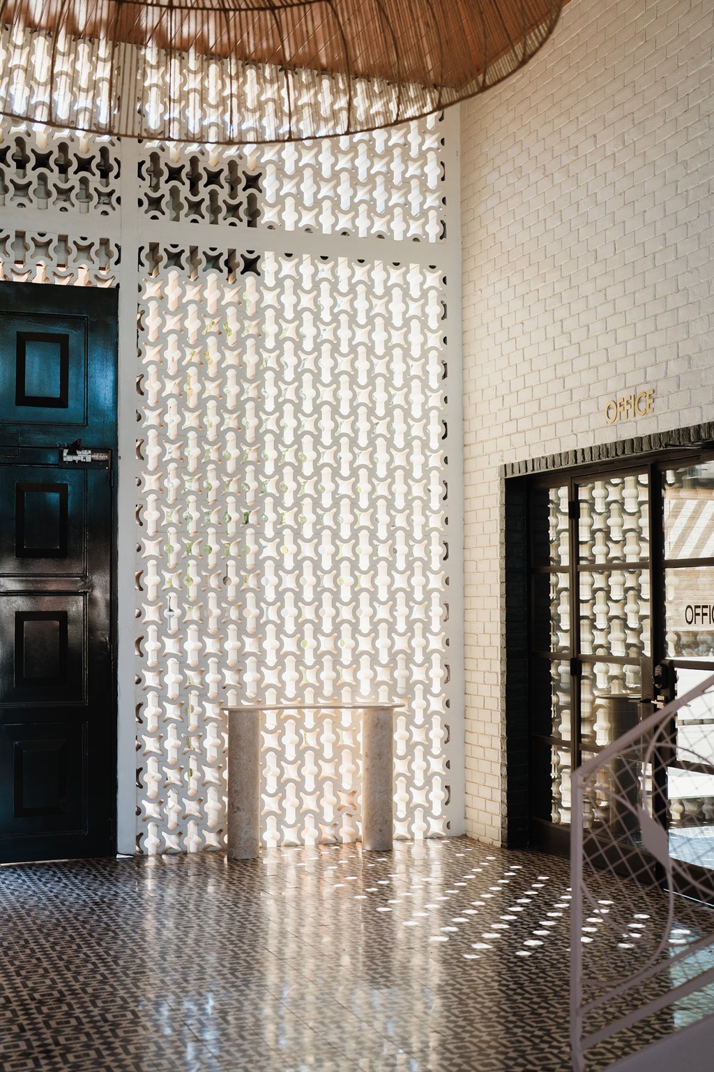 A white patterned screen separates the lobby from the office area at The PARKER on E Mulberry Apartments, San Antonio, 78209