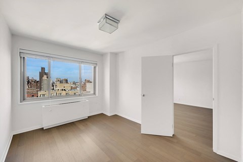 A room with a window overlooking a cityscape.