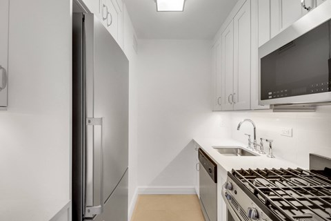A modern kitchen with a stainless steel refrigerator and oven.