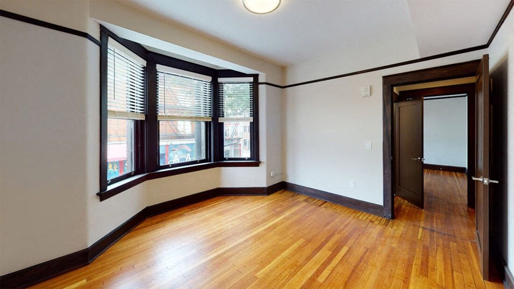 an empty living room with wood floors and windows