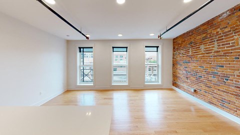 A room with a wooden floor and a brick wall.