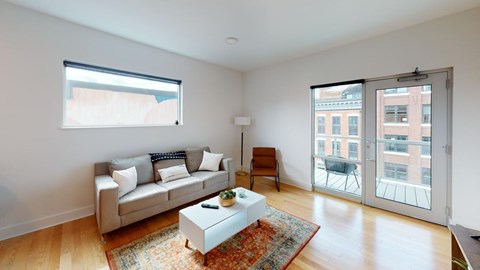 A living room with a couch, a chair, a coffee table, and a rug.