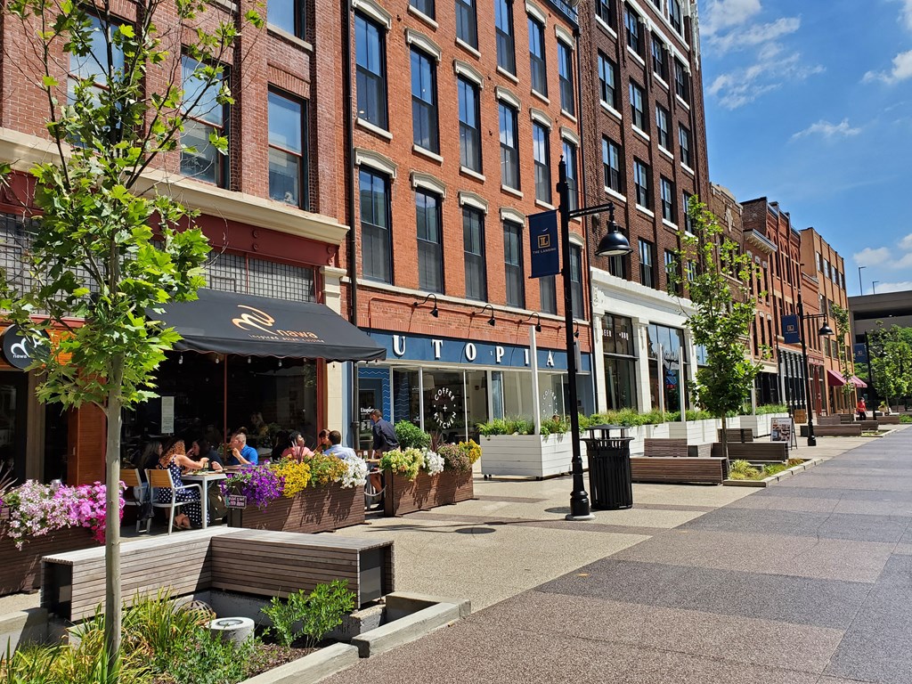 people sitting at tables outside of a brick building