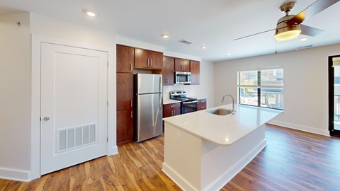 A kitchen with a white island and wooden floors.