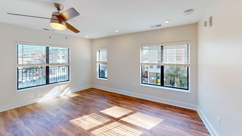 A room with a ceiling fan and wooden flooring.