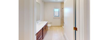 A bathroom with a toilet, sink, and mirror.