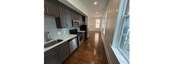 A kitchen with dark wood cabinets and stainless steel appliances.
