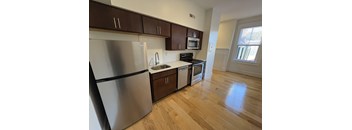 A kitchen with a stainless steel refrigerator, microwave, oven, and sink.