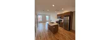 A kitchen with wooden floors and stainless steel appliances.