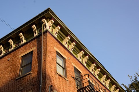 A red brick building with a green roof and white decorative elements.