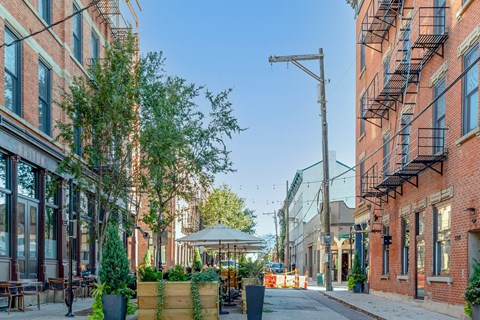 a city street with brick buildings and a gazebo on the sidewalk