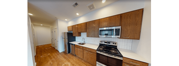 A kitchen with wooden cabinets and a black stove top oven.