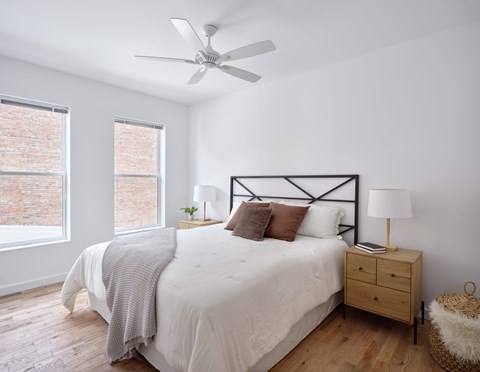 A bedroom with a bed, nightstand, and window.