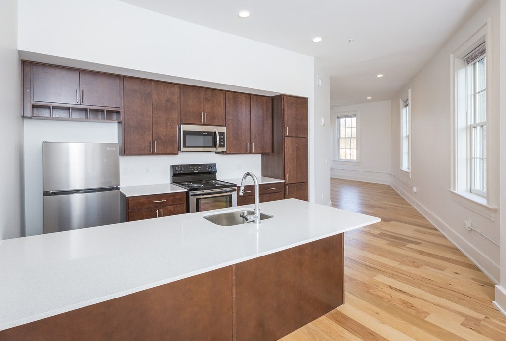 a kitchen with wooden cabinets and a white counter top