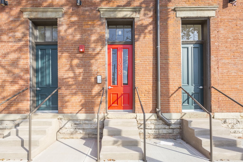 a red door on a brick building with stairs