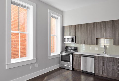 a kitchen with wooden cabinets and a stove and a window