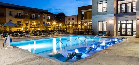 a swimming pool at night at an apartment complex