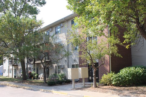 a picture of a large apartment building with trees in front of it