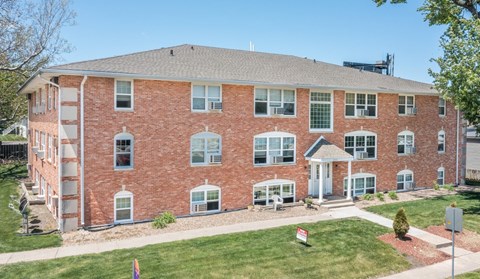 A red brick building with a white door and windows.