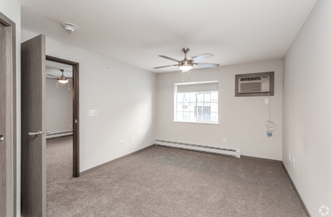 a bedroom with white walls and a ceiling fan