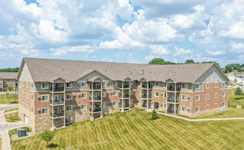 an aerial view of an apartment building with a grassy area in front of it