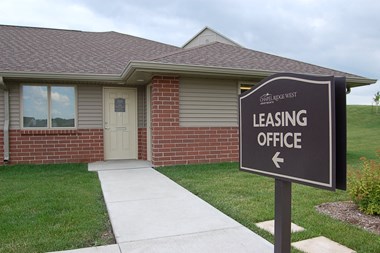 a house with a leasing office sign in front of it