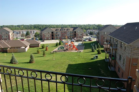 a view from a balcony of a park with a playground