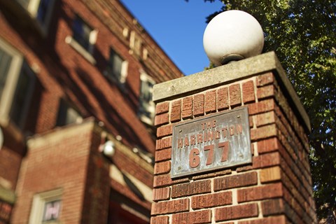 A sign on a brick wall that says "The Harrington 677".