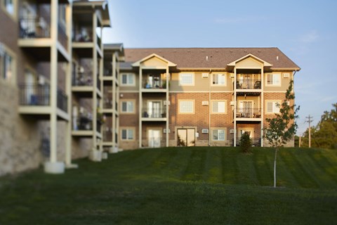 an apartment building with balconies and a lawn
