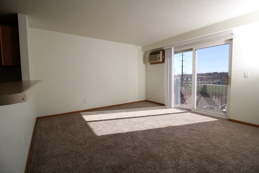 an empty living room with a sliding glass door