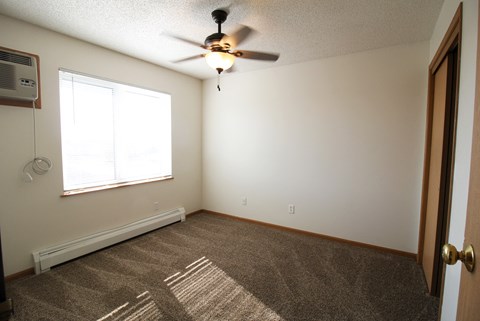 a bedroom with a ceiling fan and a window