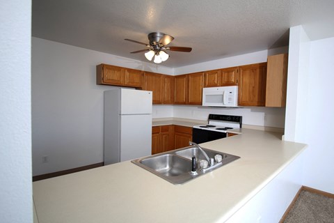 a kitchen with white appliances and wooden cabinets