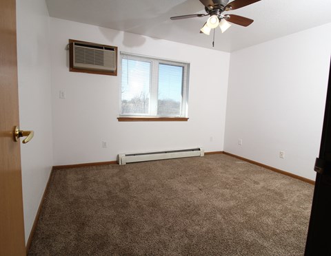 an empty room with a ceiling fan and a window