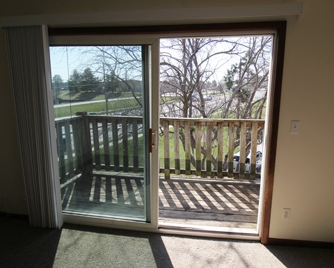 a sliding glass door in the living room leads out to a balcony with a view of the
