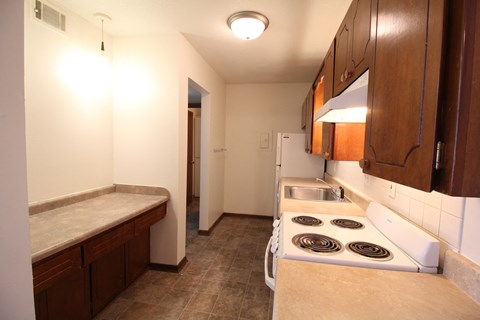 A kitchen with a stove top oven and a sink.