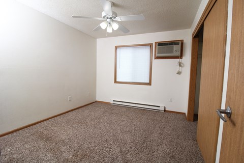 an empty room with a ceiling fan and a window