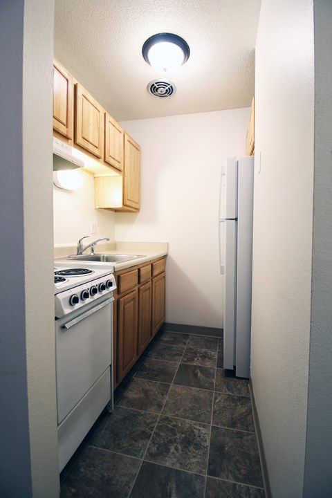 A small kitchen with a white stove and a white refrigerator.