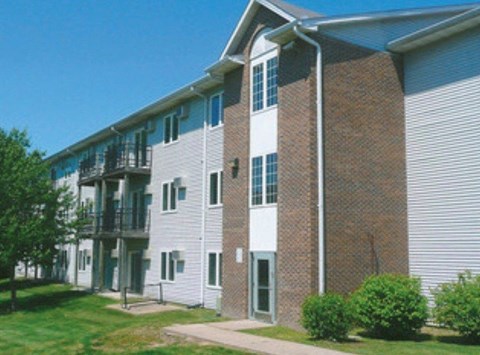 A brick building with a white door and windows.