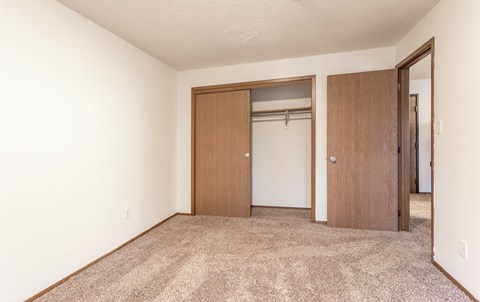 A room with a carpeted floor and two doors.
