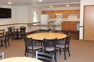 A kitchen with a table and chairs in front of it.