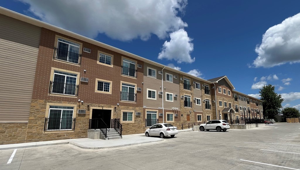 a large brick apartment building with cars parked outside