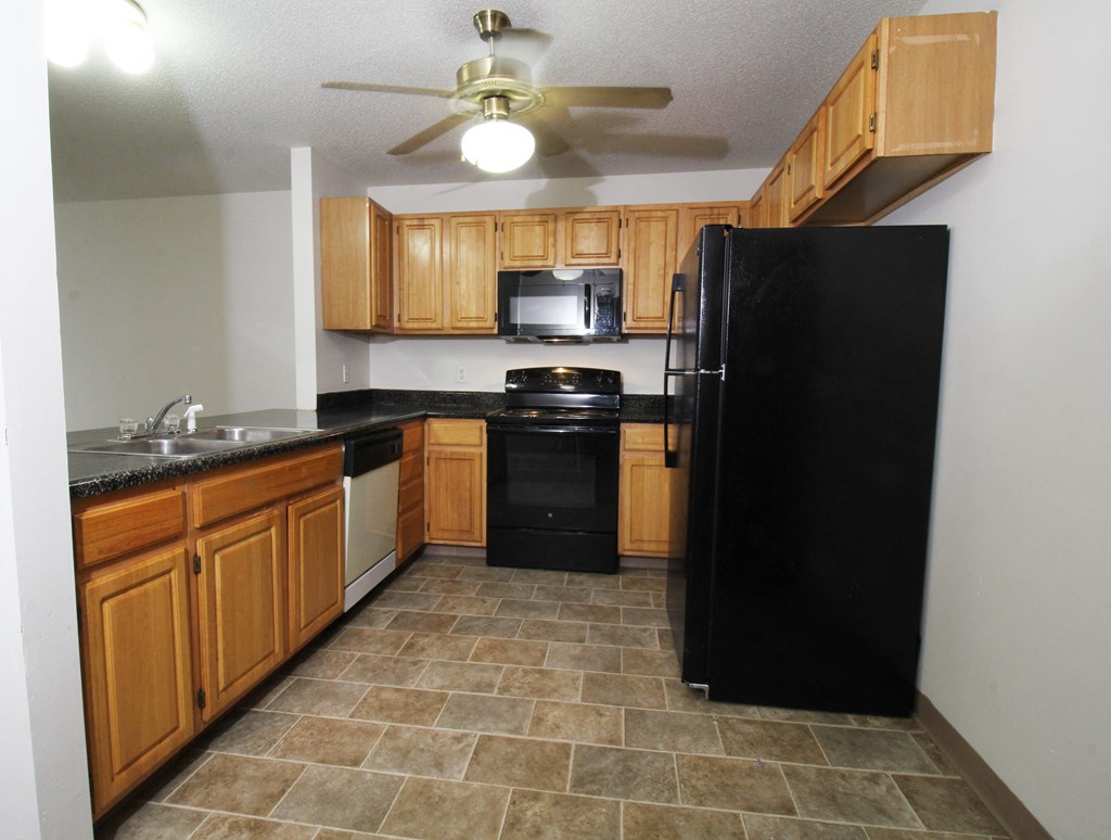 a kitchen with wood cabinets and black appliances