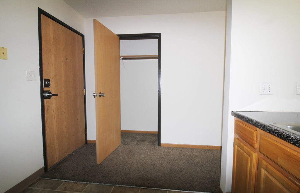 an open door leads into a small room with a sink and a countertop