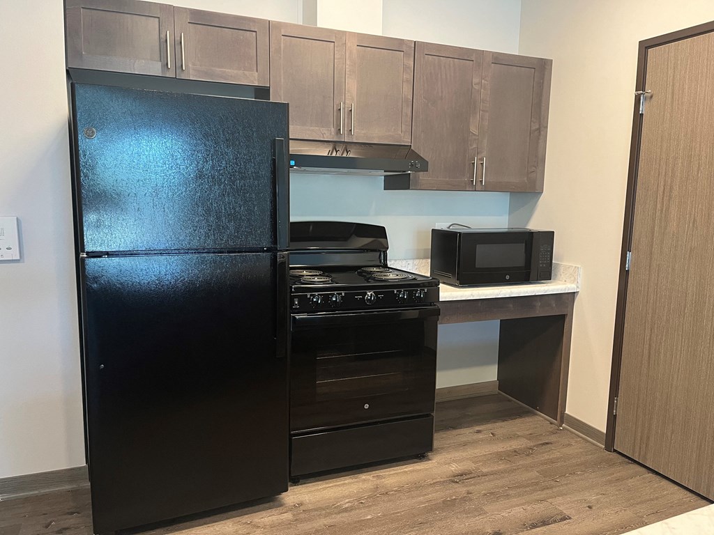 a kitchen with black appliances and a counter with a refrigerator