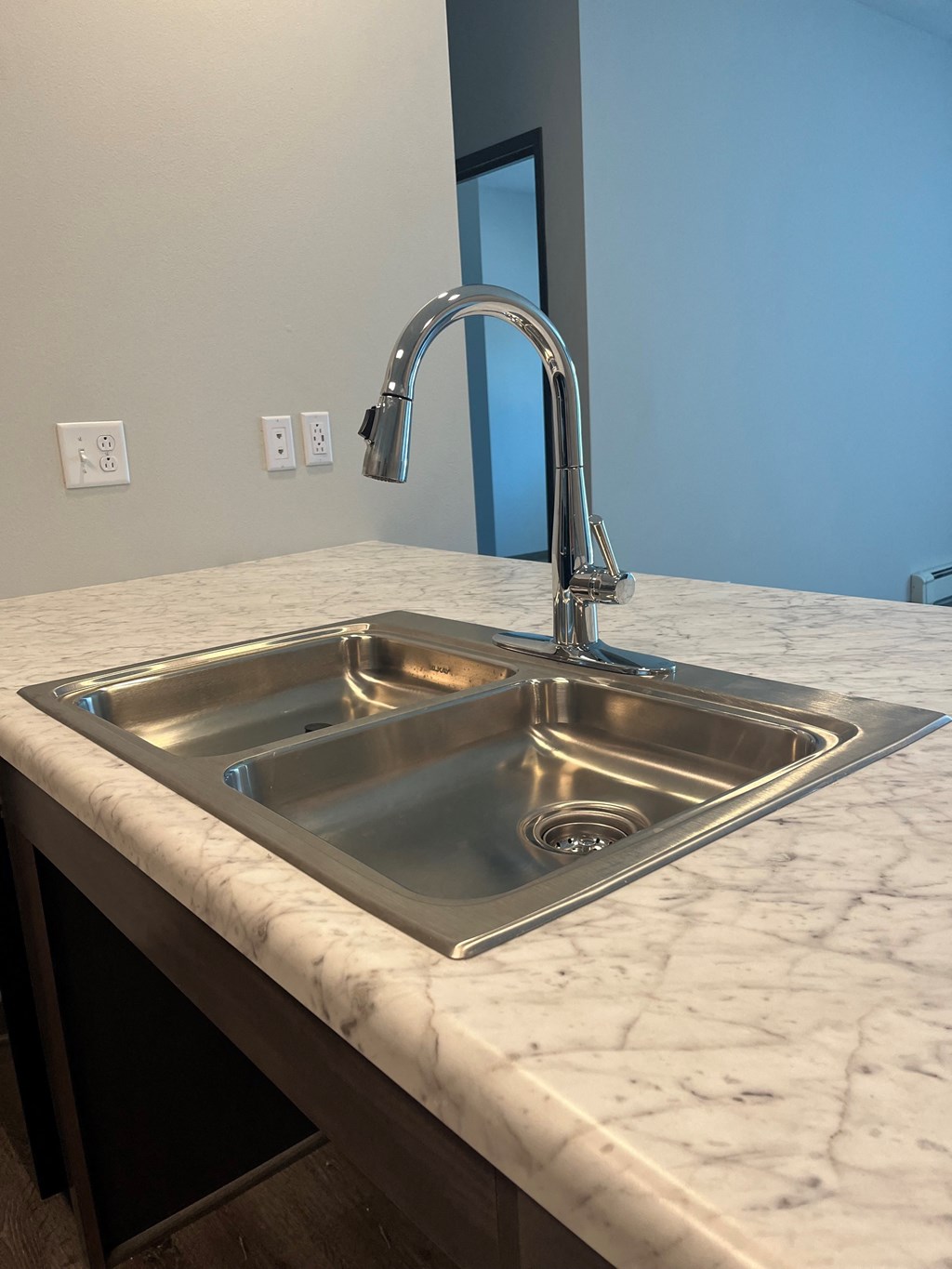 a stainless steel sink in a marble counter top in a kitchen