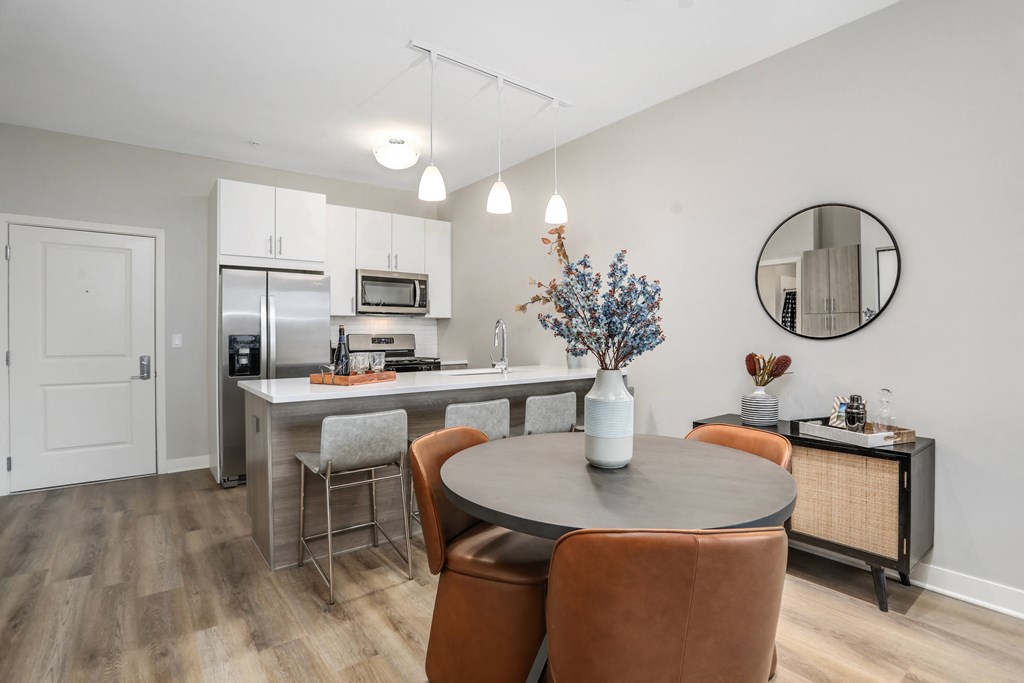 a dining area with a table and chairs and a kitchen with stainless steel appliances at Beekman on Broadway, Ann Arbor