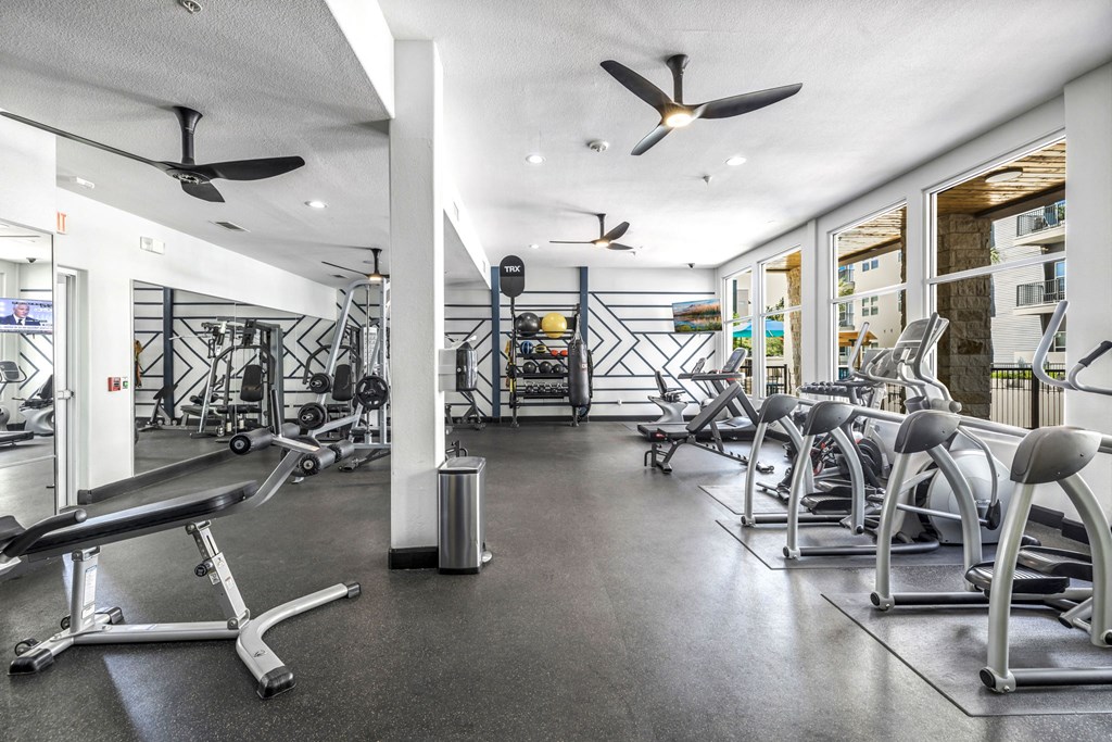 a workout room with a variety of exercise equipment a workout room with a variety of exercise equipment at Urban Crest Apartments, Texas