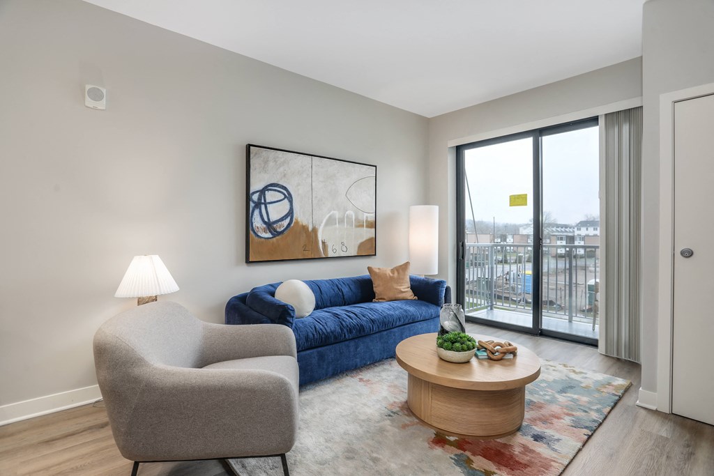a living room with a couch and a chair and a sliding glass door at Beekman on Broadway, Ann Arbor, Michigan